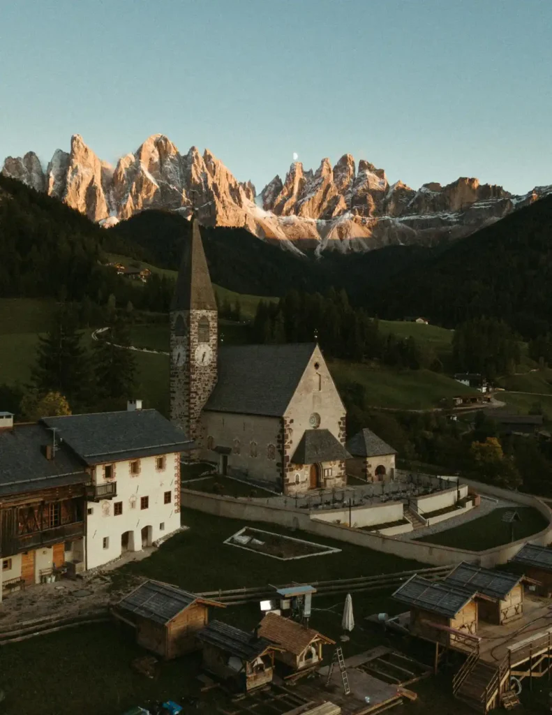 An ancient mountain village with iconic stone towers and lush green valleys in daylight.