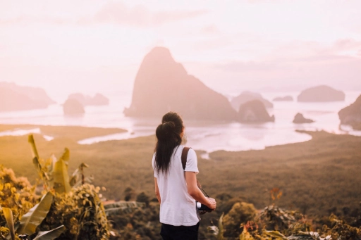 A woman facing the seashore with rock formations